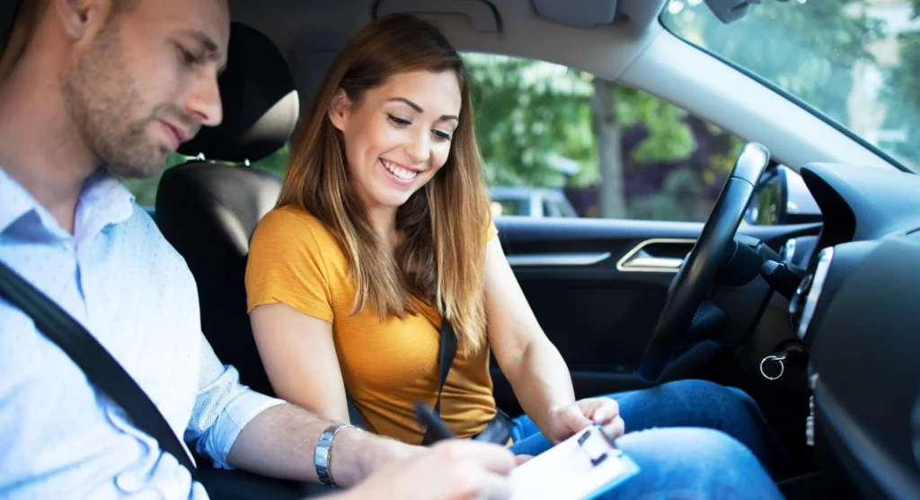 Aquí tienes la traducción directa de la frase aplicando la conjugación de tú (asumiendo el papel protagónico en la acción): "Una pareja en el interior de un carro en movimiento, contigo sonriendo mientras ajustas o sujetas el tablero, y el hombre a tu lado, ambos usando cinturones de seguridad y manejando con atención al tránsito