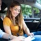 Aquí tienes la traducción directa de la frase aplicando la conjugación de tú (asumiendo el papel protagónico en la acción): "Una pareja en el interior de un carro en movimiento, contigo sonriendo mientras ajustas o sujetas el tablero, y el hombre a tu lado, ambos usando cinturones de seguridad y manejando con atención al tránsito