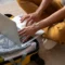 Pessoas trabalhando em equipe com um notebook aberto no chão, com roupas dobradas ao lado, ambiente doméstico e colaboração para organizar ou planejar tarefas
